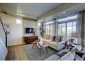 Sun-filled living room boasts large windows, modern fixtures, and stylish decor at 1200 Sugarloaf Ln, Erie, CO 80516