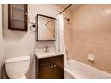 Cozy bathroom featuring tiled walls, a granite countertop, and a shower-tub combo at 1365 Clayton St, Denver, CO 80206