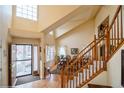 Grand foyer with soaring ceilings, hardwood floors, staircase, and dining area with large windows for natural light at 2829 S Fig St, Lakewood, CO 80228