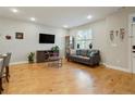 Comfortable living room featuring a leather sofa, wood floors, and a stylish display cabinet at 16461 E 119Th Way # B, Commerce City, CO 80022