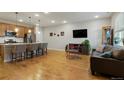 Open concept living space with hardwood floors connecting the kitchen and a cozy living area at 16461 E 119Th Way # B, Commerce City, CO 80022