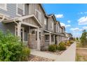 Inviting townhomes with stone accents and well-manicured landscaping along a sidewalk at 16461 E 119Th Way # B, Commerce City, CO 80022