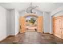 Inviting foyer with tile floors, wood trim, arched doorway, and modern chandelier at 156 S Lookout Mountain Rd, Golden, CO 80401