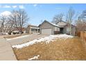 Inviting single-Gathering home featuring a two-car garage and well-maintained front yard with mature trees at 3695 Quail St, Wheat Ridge, CO 80033