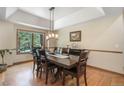 Bright dining room with hardwood floors, modern lighting, and a large window overlooking the trees at 19165 Golden Arrow Cir, Monument, CO 80132