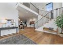 Grand two-story foyer with hardwood floors, staircase, and view into the dining and living spaces at 815 E Westglow Ln, Greenwood Village, CO 80121