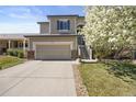 Inviting home features a two-car garage, well-manicured lawn, and blossoming tree at 468 Sylvestor Trl, Highlands Ranch, CO 80129