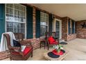 Inviting front porch with brick accents, comfortable seating, and decorative plants at 2225 Clayton Cir, Superior, CO 80027