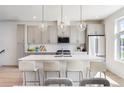 Modern kitchen featuring a large island with seating, stainless steel appliances, and stylish pendant lighting at 22 Oneida Ct, Denver, CO 80230