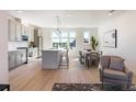 Bright open floor plan features updated kitchen, adjacent dining area, and stylish living space with hardwood floors at 22 Oneida Ct, Denver, CO 80230