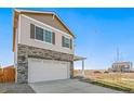 Two-story home with stone accents, two-car garage, and a charming porch, set against a clear blue sky at 18029 Dandy Brush Ln, Parker, CO 80134