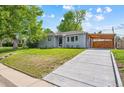 Well-maintained home featuring a lush lawn, covered parking, and a concrete driveway at 1888 S Filbert Ct, Denver, CO 80222