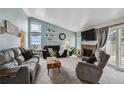 Bright living room featuring vaulted ceilings, a brick fireplace, and plenty of natural light at 646 S Joplin St, Aurora, CO 80017