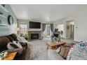 Spacious living room with a brick fireplace, plush seating, and access to the outdoors at 646 S Joplin St, Aurora, CO 80017