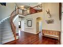 Grand foyer featuring hardwood floors, a curved staircase and natural light from above at 8720 E 163Rd Pl, Brighton, CO 80602