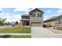 Inviting two-story home boasts a covered porch, an attached two car garage, and manicured front lawn at 603 Jewel St, Brighton, CO 80603