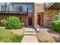 Inviting entrance with a red door, stone accents and landscaped yard at 2763 W Riverwalk Cir # B, Littleton, CO 80123
