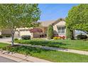 Well-kept home features a three-car garage and lush front lawn at 4965 Bierstadt Loop, Broomfield, CO 80023