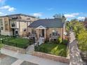 Charming brick home with a manicured lawn, black fencing, and professional landscaping at 4495 Utica St, Denver, CO 80212