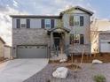 Beautiful two-story home with stone and gray siding, a well-manicured lawn, and a two-car garage at 1918 S Coolidge Way, Aurora, CO 80018