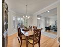 Elegant dining room features a wood table, chandelier, and windows with bright natural light at 8646 Fawnwood Dr, Castle Pines, CO 80108