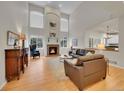 Spacious living room with a fireplace, a two-story ceiling, and large windows at 8646 Fawnwood Dr, Castle Pines, CO 80108