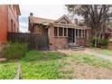 Charming brick home featuring a cozy front porch and adjacent wooden fence at 1445 Saint Paul St, Denver, CO 80206