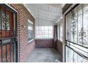 Enclosed front porch featuring brick walls, concrete floor, and decorative metal grates at 1445 Saint Paul St, Denver, CO 80206