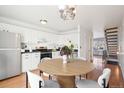 Charming kitchen features white cabinetry, stainless steel appliances, and a cozy dining area with a round table and modern chairs at 8975 Field St # 39, Broomfield, CO 80021