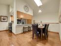 Bright dining area with stylish lighting, wood floors, and seamless kitchen access at 6321 S Harrison Ct, Centennial, CO 80121