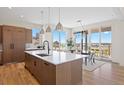 Island kitchen with stainless appliances, white countertop, and dining area at 6176 Oxford Peak Ln, Castle Rock, CO 80108