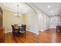 Elegant dining room featuring gleaming wood floors, a coffered ceiling, and stylish chandelier lighting at 9744 W Ontario Pl, Littleton, CO 80128