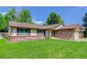 Single Gathering home with brick and stone accents and a freshly mowed front lawn at 633 S Galena St, Denver, CO 80247