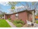 Side view of brick home featuring a landscaped yard, walkway, and seating area at 2459 S Corona St, Denver, CO 80210