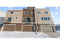 Stylish townhome with balcony above garage, featuring a modern design and snow-covered landscape at 14241 Currant St, Broomfield, CO 80020