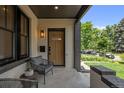 Inviting covered porch with seating area and stylish light fixture at 2569 Forest St, Denver, CO 80207