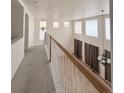 Upstairs hallway overlooking living area with high ceilings and lots of natural light at 10475 Applebrook Cir, Highlands Ranch, CO 80130
