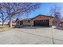 Brick and siding home featuring an attached two-car garage and wide driveway at 1376 S Zephyr Ct, Lakewood, CO 80232