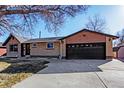 Front exterior of brick and siding home with two-car garage and wide driveway at 1376 S Zephyr Ct, Lakewood, CO 80232