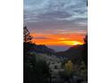 Breathtaking sunset view over the mountains, painted with vivid oranges and purples at 2120 Gross Dam Rd, Golden, CO 80403