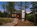 Attractive multi-level home featuring an attached garage with a rock lined pathway at 13910 Blue Jay Ln, Larkspur, CO 80118