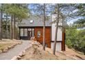 Charming multi-level home featuring an attached garage and a rock lined pathway at 13910 Blue Jay Ln, Larkspur, CO 80118