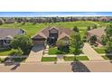 Aerial view of a single-Gathering home with beautiful landscaping and a well-manicured lawn near a golf course at 22023 E Heritage Pkwy, Aurora, CO 80016