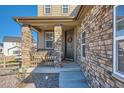 Inviting front porch showcasing stone pillars and a welcoming wreath on the front door at 8137 Ralston Creek Ave, Littleton, CO 80125