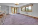 Spacious living room features neutral carpet, white walls, and multiple windows at 5336 High Rd, Evergreen, CO 80439