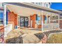 Inviting front porch with white railing and brick exterior at 6610 S Waco Way, Aurora, CO 80016