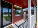 Cozy front porch with white pillars and view of a well-kept lawn and nearby street at 1955 Ingalls St, Lakewood, CO 80214