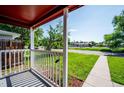 Charming front porch view with white railings looking out to a lush green lawn and quiet street at 1955 Ingalls St, Lakewood, CO 80214