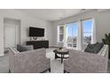 Cozy living room featuring neutral tones, balcony access, and a sleek entertainment center at 14321 E Tennessee Ave # 1-301, Aurora, CO 80012