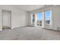 Bright and spacious living room featuring large windows and balcony access, showcasing ample natural light at 14321 E Tennessee Ave # 1-301, Aurora, CO 80012